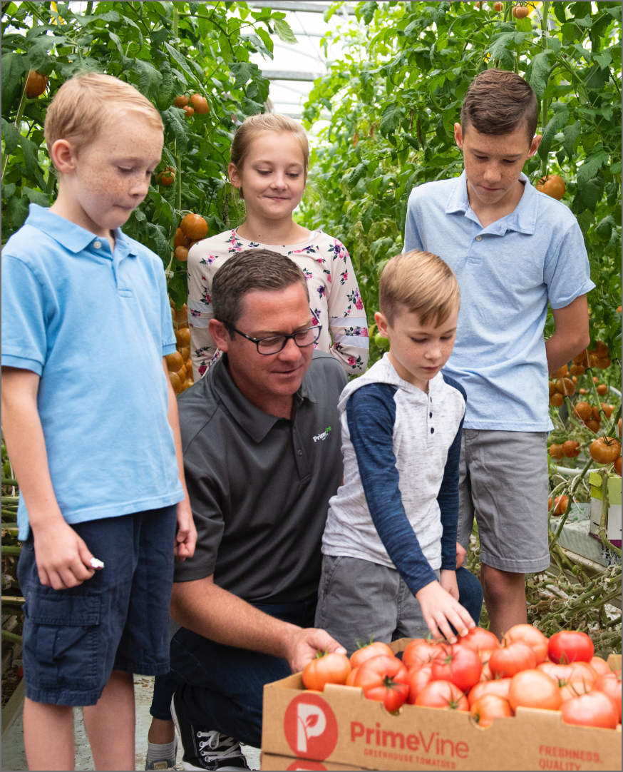 Photo of Abe and kids looking at tomatoes